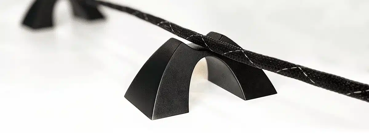 Cable Arch™ cable elevator lifting a speaker cable for cleaner routing and improved organization