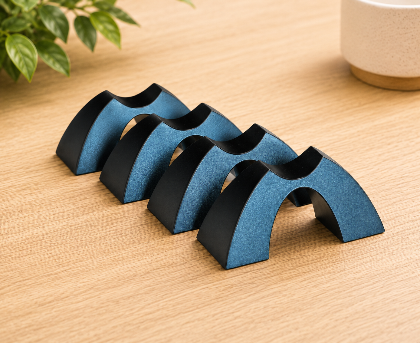Four Cable Arch speaker cable elevators arranged on a light wood surface in a clean listening room environment.