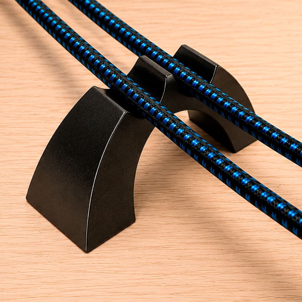 Cable Arch Duo speaker cable supports holding paired speaker cables above a wood floor